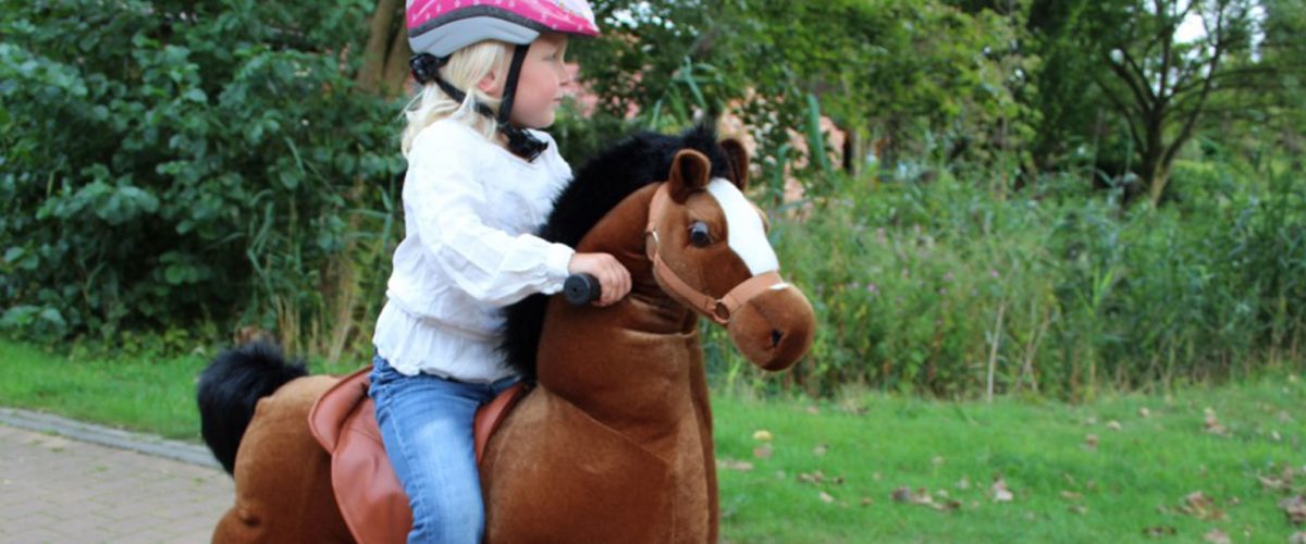 Meisje op speelgoed paard