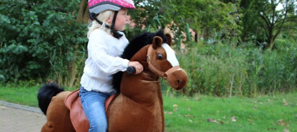 Meisje op speelgoed paard